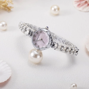 Detail of luxury women's bracelet watch with pink mother of pearl dial and pearl band