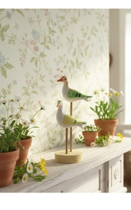 Detailed close-up of decorative wooden sea bird figurines on a modern minimalist pedestal