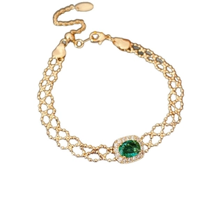 Vintage gold mesh bracelet with oval green gemstone and zircon halo on white background