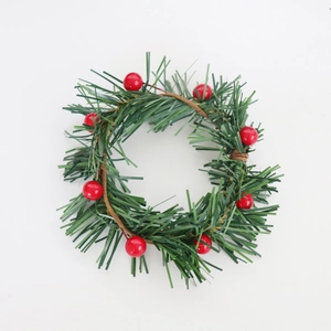 Close-up of mini Christmas candle ring with red berries and green pine needles decoration