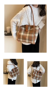 Detail of a brown plaid wool tote bag featuring premium leather straps and button closure