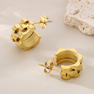 Vue détaillée des boucles d'oreilles créoles plaquées or 18K avec texture de bracelet de montre