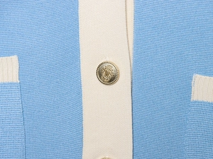 Macro shot of gold embossed metal buttons on a blue and cream knit cardigan