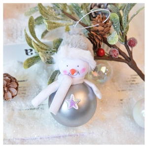 Detail view of a plush snowman bauble ornament with festive pine cone and snow decorations