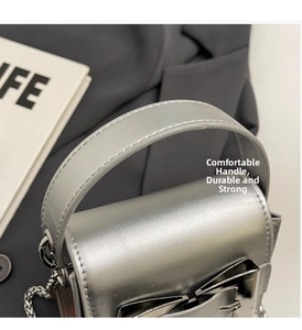Detail of silver mini crossbody bag with metal chain strap and reinforced top handle
