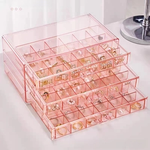 Close-up of three-tier pink acrylic jewelry organizer with divided storage drawers
