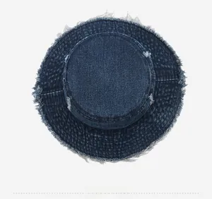 Top down view of a deep blue denim bucket hat with distressed frayed edges and washed finish