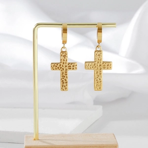 Orecchini a croce dorati con trama a nido d'ape su supporto per gioielli elegante