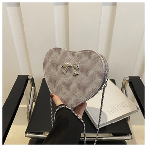 Macro detail of lavender heart-shaped bag with embossed patterns and metal bow buckle