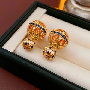 Gros plan détaillé de boucles d'oreilles vintage plaquées or 18k avec zircons colorés en boîte