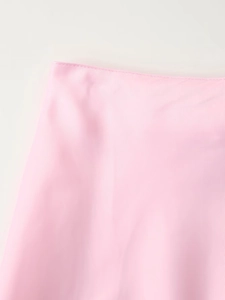 Detail of light pink satin skirt waistband showing high-quality stitching and smooth texture