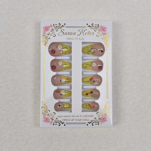 Close-up of almond press-on nails with 3D ladybug, bee motifs and pearl accents