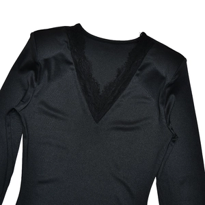 Dettaglio dello scollo a V con eleganti cuciture in pizzo su un top nero a maniche lunghe