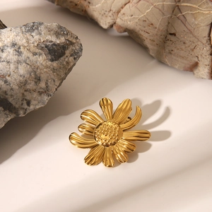 Détail macro d'une pince à cheveux marguerite dorée aux textures de pétales fines