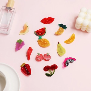 Detailed view of colorful acrylic fruit hair clips including strawberry and watermelon designs
