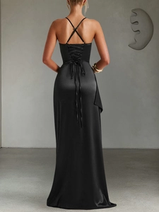 Detail of the cross-back lace-up design and draped satin fabric on a black evening gown