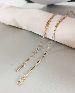Detail of gold titanium steel curb chain necklace featuring lobster clasp and extender
