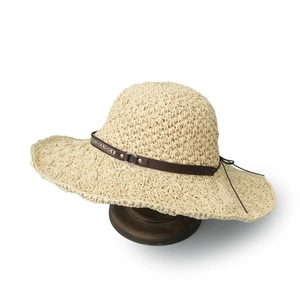 Detail of hand-woven sun hat with ethnic leather belt and vintage metal buckle