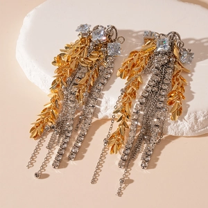 Detailed macro view of cascading gold wheat leaf earrings with silver rhinestone tassels