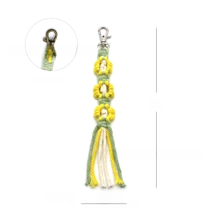 Detail view of handmade woven flower keychain with lobster clasp and long tassel