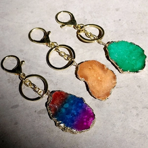 Detailed macro view of natural agate stone slices on gold-plated keychain rings