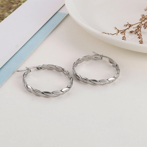 Macro view of silver twisted braided hoop earrings in polished stainless steel