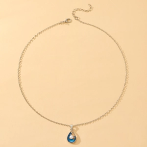 Detail of blue enamel teardrop pendant with white pearl and silver lobster clasp chain