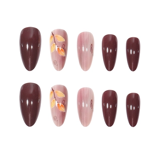 Deep red and marble almond press-on nails with leaf patterns and cat-eye finish