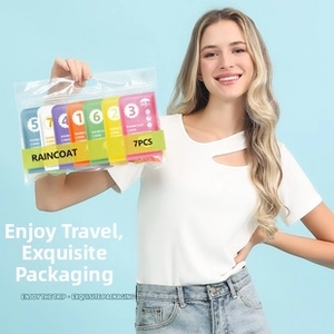 Close-up of seven colorful card-sized portable compressed raincoats in zipper bags