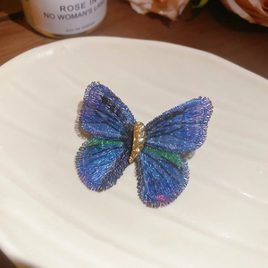 Detail of embroidered butterfly brooch with blue and green gradient silk threads