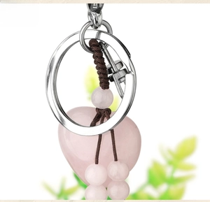 Close-up of pink heart crystal keychain with handmade woven tassels and beads