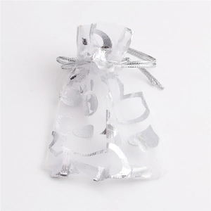 Detailoverzicht van wit organza cadeauzakje met zilveren hartpatronen en trekkoord