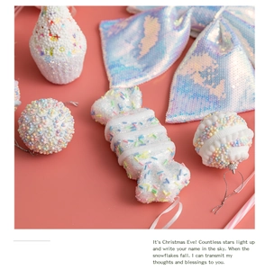 Detail of white foam candy and glitter cupcake ornaments on a coral pink background