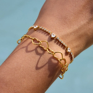 Close-up of double-layered gold heart bracelet set with zircon stones on model's wrist