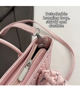 Detail of pink woven leather bucket bag with silver zipper and detachable shoulder strap