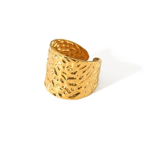 Detail of wide adjustable gold ring featuring premium hammered metal texture and glossy finish