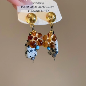 Detail of vintage flower earrings with 925 silver needles and amber beads