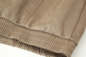 Detail view of khaki suede jacket featuring elastic ribbed cuffs and double stitching