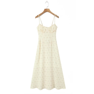 Close-up of the delicate floral pattern and slender straps on the yellow summer midi dress