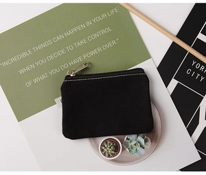 Detail of a black canvas coin purse with silver zipper and precise stitching texture