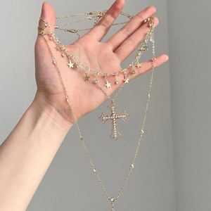 Three-layer gold necklace with rhinestone cross and star pendants in a vintage style