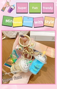Close-up of cat bubble tea keychain with laser wrist strap and golden metal ring