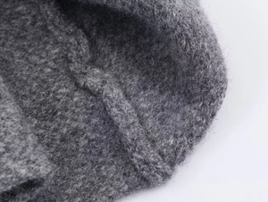 Vista macro della trama del tessuto a maglia grigio scuro con dettagli delle fibre