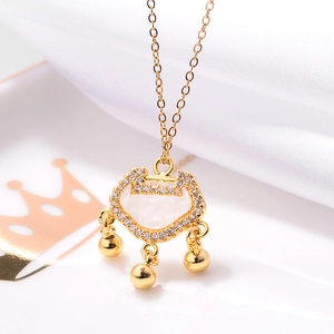 Detail of rose gold Ruyi lock pendant with white jade center and bells on white silk