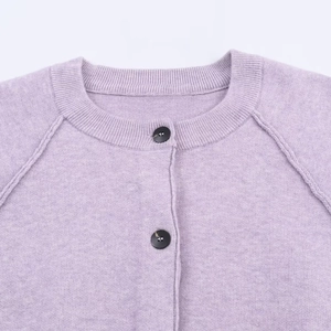 Close-up of lavender knitted cardigan featuring a ribbed crew neck and black buttons