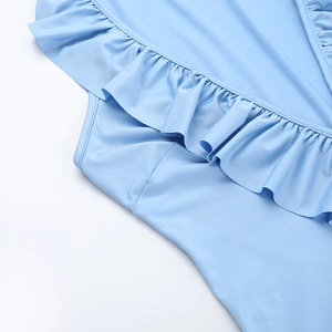 Détail rapproché des volants bleu clair et du ruban fluide sur la robe d'été
