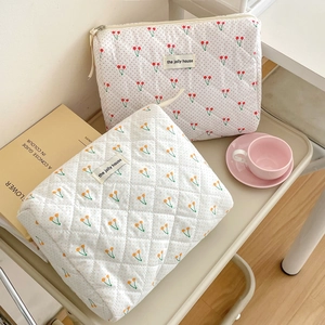 Détail trousse de maquillage cerise matelassée avec rembourrage doux et fermeture éclair