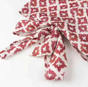 Close-up of red and white floral print fabric featuring a tie-bow knot detail