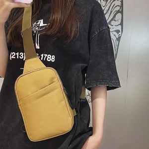 Unisex mustard yellow canvas crossbody chest bag with adjustable strap on model