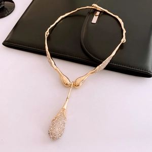 Détail du collier doré à texture de lave avec pendentif goutte d'eau serti de cristaux